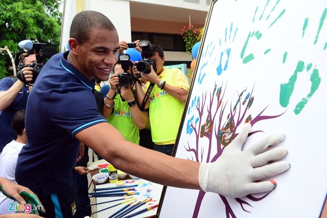 Tiền vệ Fernando dùng tay in lên bức tranh để làm quà tặng cho trẻ em ở làng SOS.