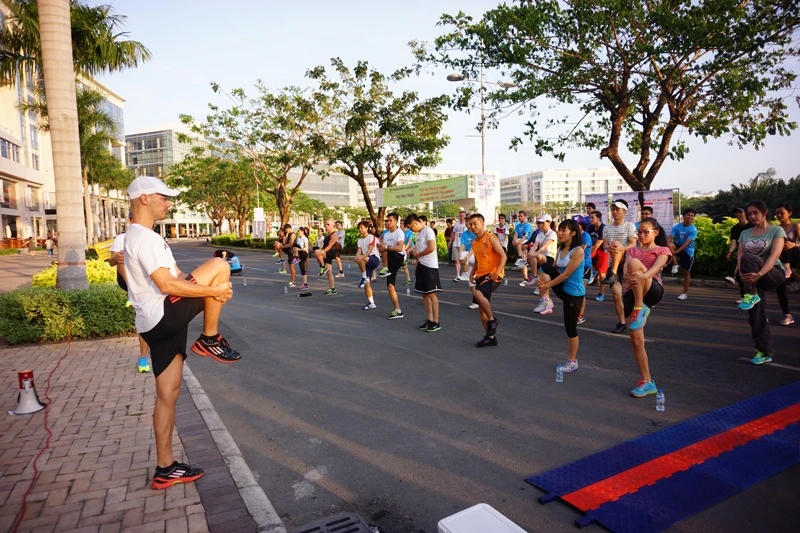 HLV Stephane Laporte đang hướng dẫn các thành viên tham gia thư giãn cơ sau buổi tập chạy.