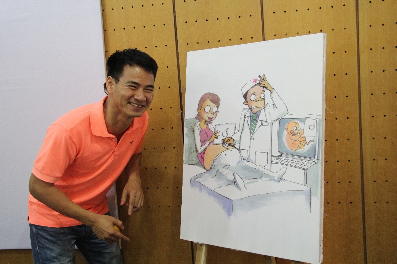 Nghệ sĩ Xuân Bắc với phần bình luận siêu tưởng bức tranh được các họa sĩbiếm họa vẽ bằng màu nhuộm Elumen ngay trong buổi họp báo.