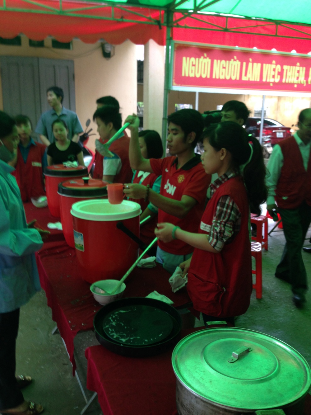 Nhân viên GENVIET đang múc cháo cho các bệnh nhân.