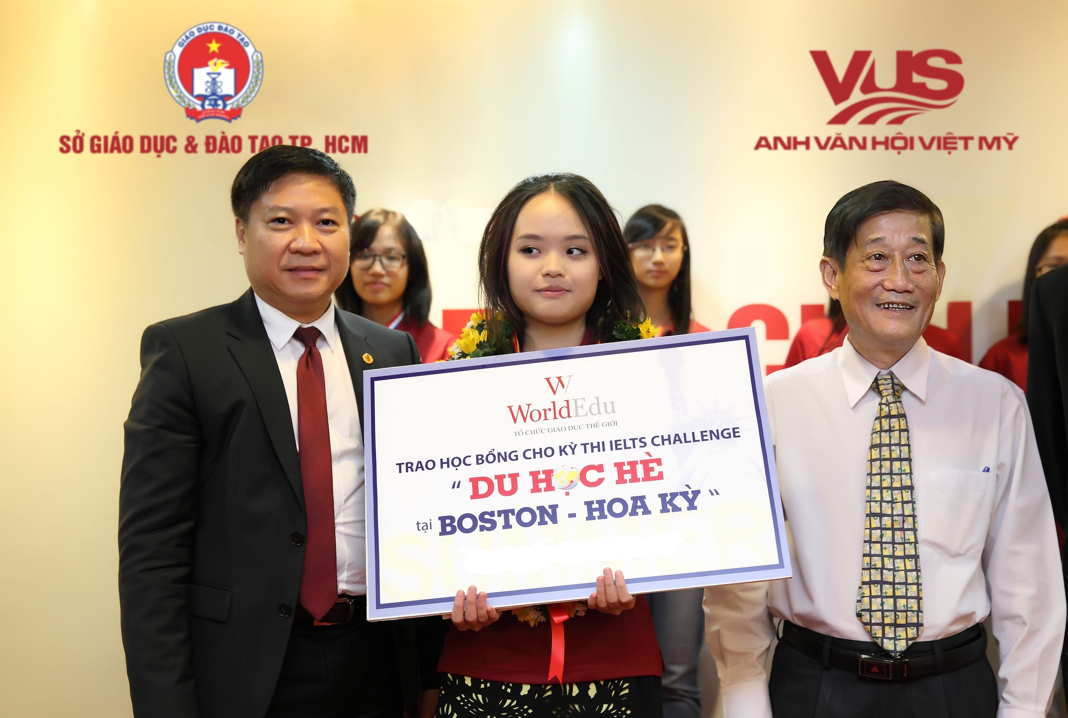 Quán quân Bùi Nguyễn Quỳnh Nhi nhận giải thưởng từ ông Nguyễn Tiến Đạt - Bí thư Đảng ủy, Phó giám đốc Sở GDĐT TPHCM và ông Phạm Tấn Nghĩa - Chủ tịch HĐQT, TGĐ Hệ Thống Anh Văn Hội Việt Mỹ.