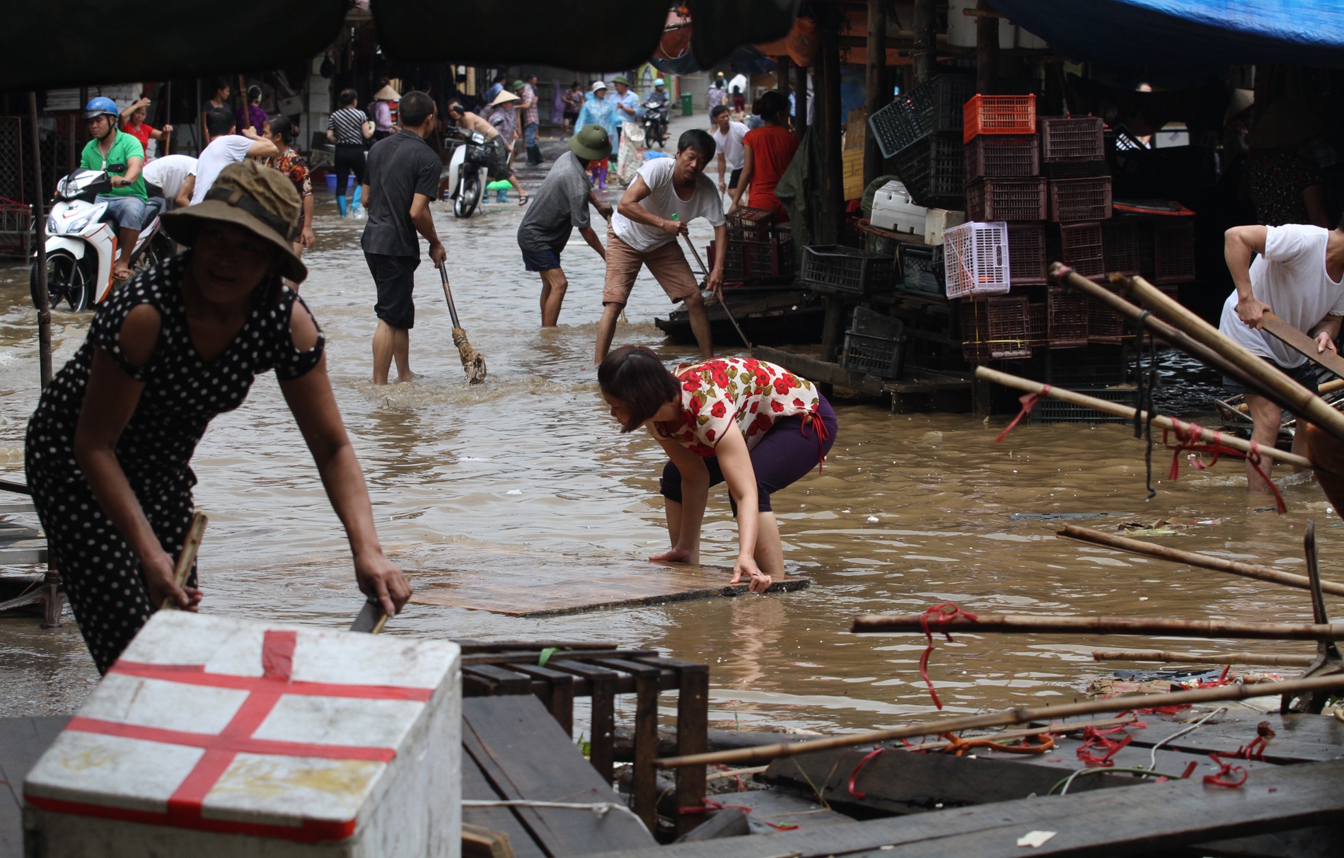 11.	Chị Chung đang còng người kéo chiếc bàn bán thịt của gia đình bị nước cuốn trôi cách đó 60m.