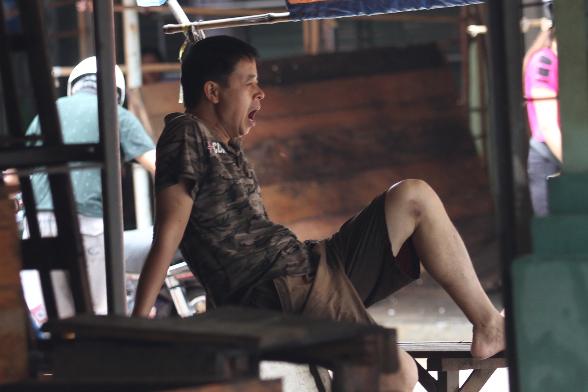 12.	Sự mệt mỏi, ể oải hiện rõ trên khuôn mặt của những tiểu thương chợ Giếng Vuông.