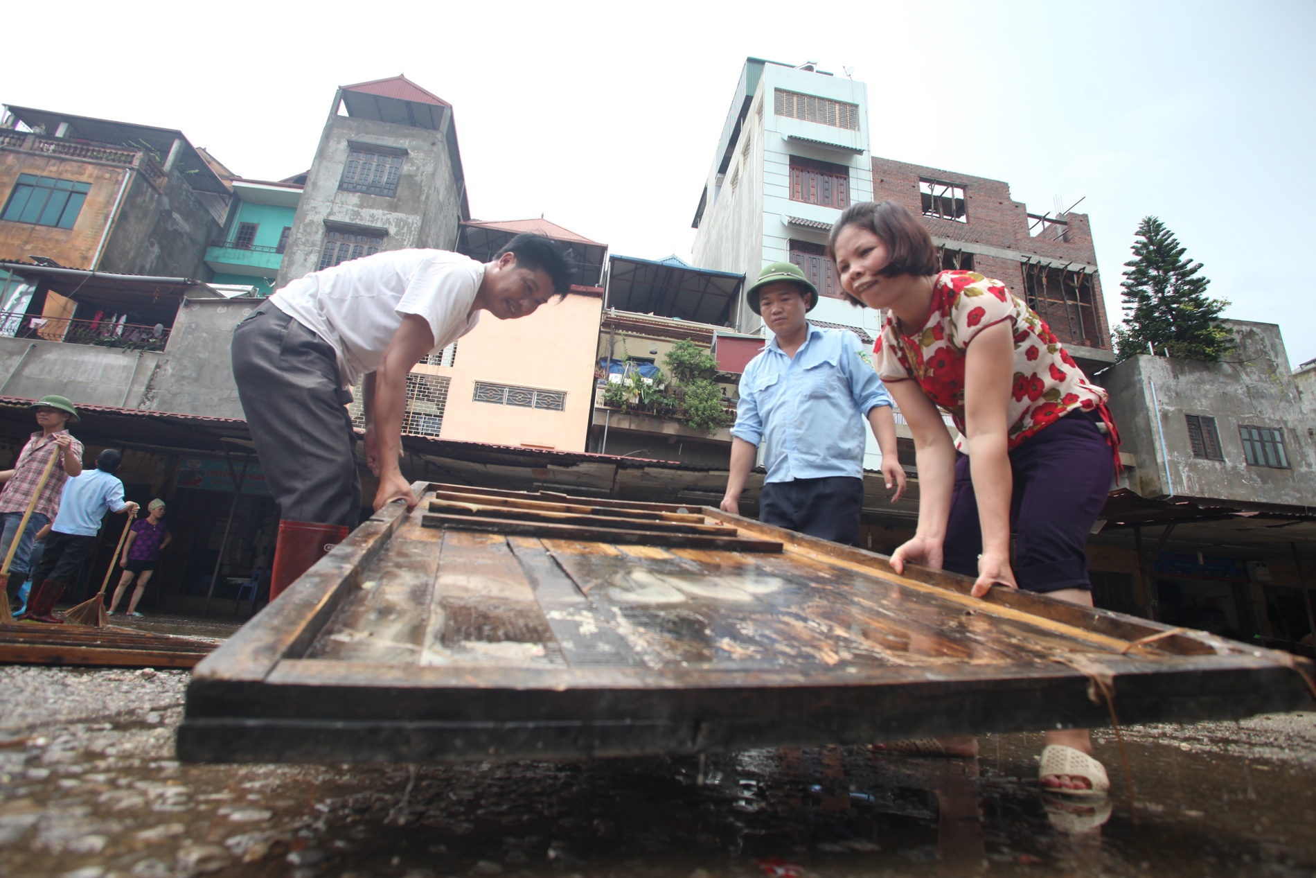 7.	Vẻ mặt trầm tư của một chủ cửa hàng buôn bán ở cuối chợ khi cơn mưa đổ xuống và nước vẫn còn quá cao, chị nói, Từ sáng chị đã đi ra đi vào chợ nhiều lần để kiểm tra đồ đạc và xem mực nước rút để có thể dọn dẹp trở lại buôn bán.