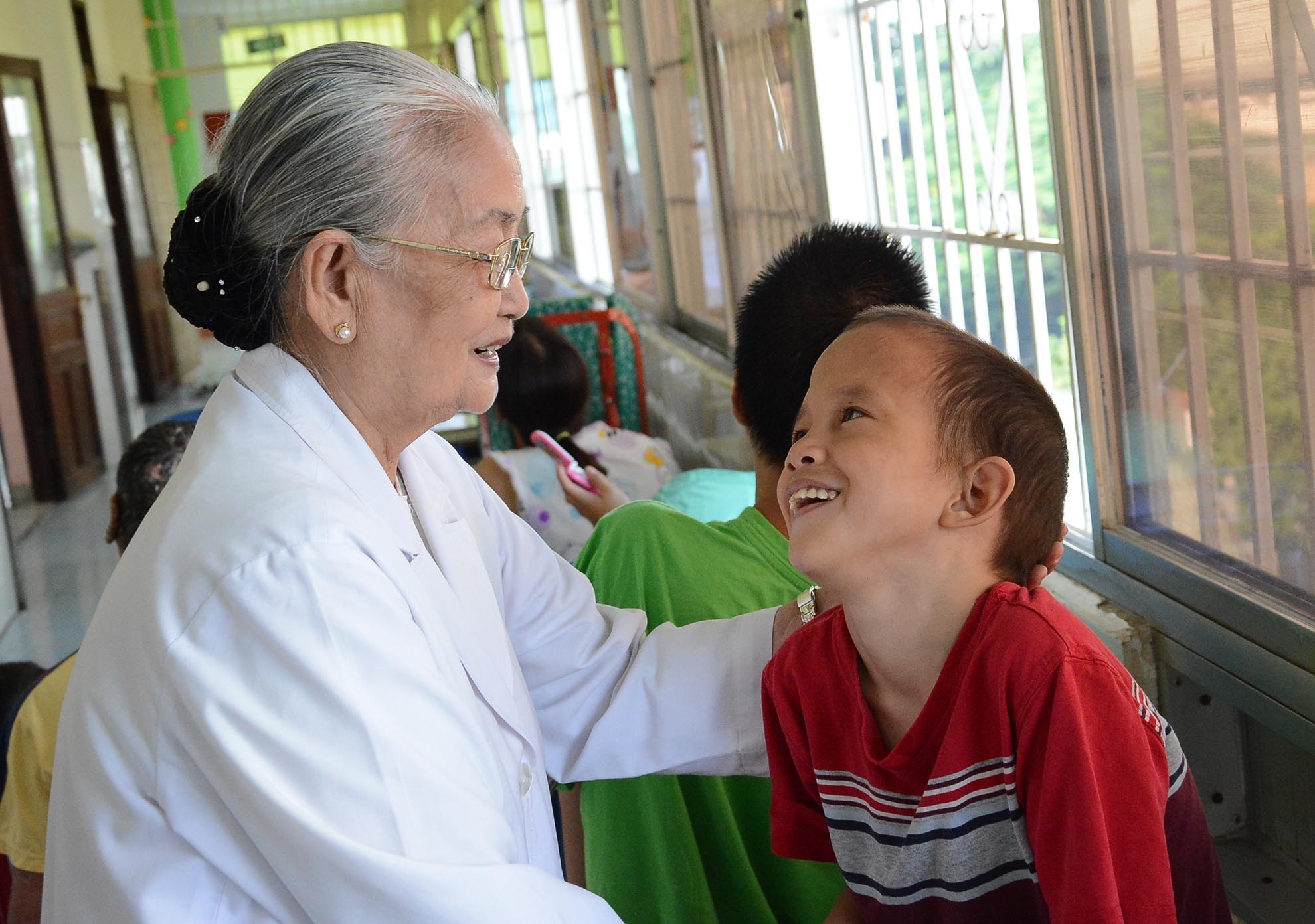 Em Nguyễn Thị Thùy Giang mừng quýnh khi được “bà nội” tới thăm. Em Giang bị bệnh bại não và được các bác sĩ của làng Hòa Bình nhận về nuôi dưỡng.