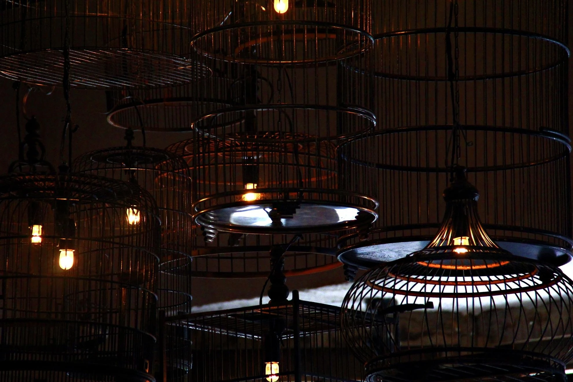 Những chiếc lồng nhốt cú đêm hắt ánh sáng le lét qua nan tre kéo bóng đêm vây kín không gian.