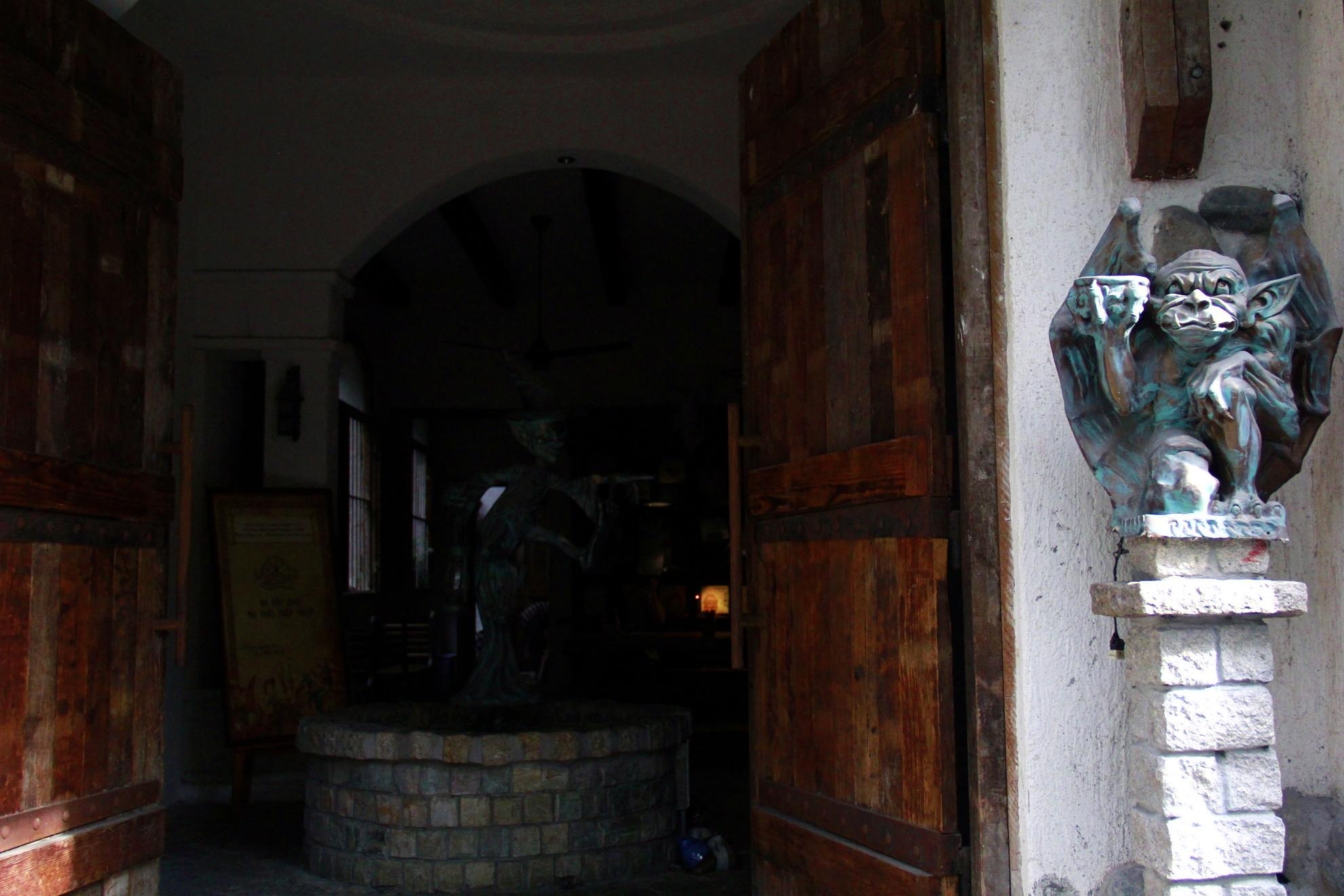 Cửa vào được canh gác bởi một chú quỷ nhỏ, bên cạnh là cánh cửa gỗ lớn dày làm khách vừa hồi hộp vừa tò mò.