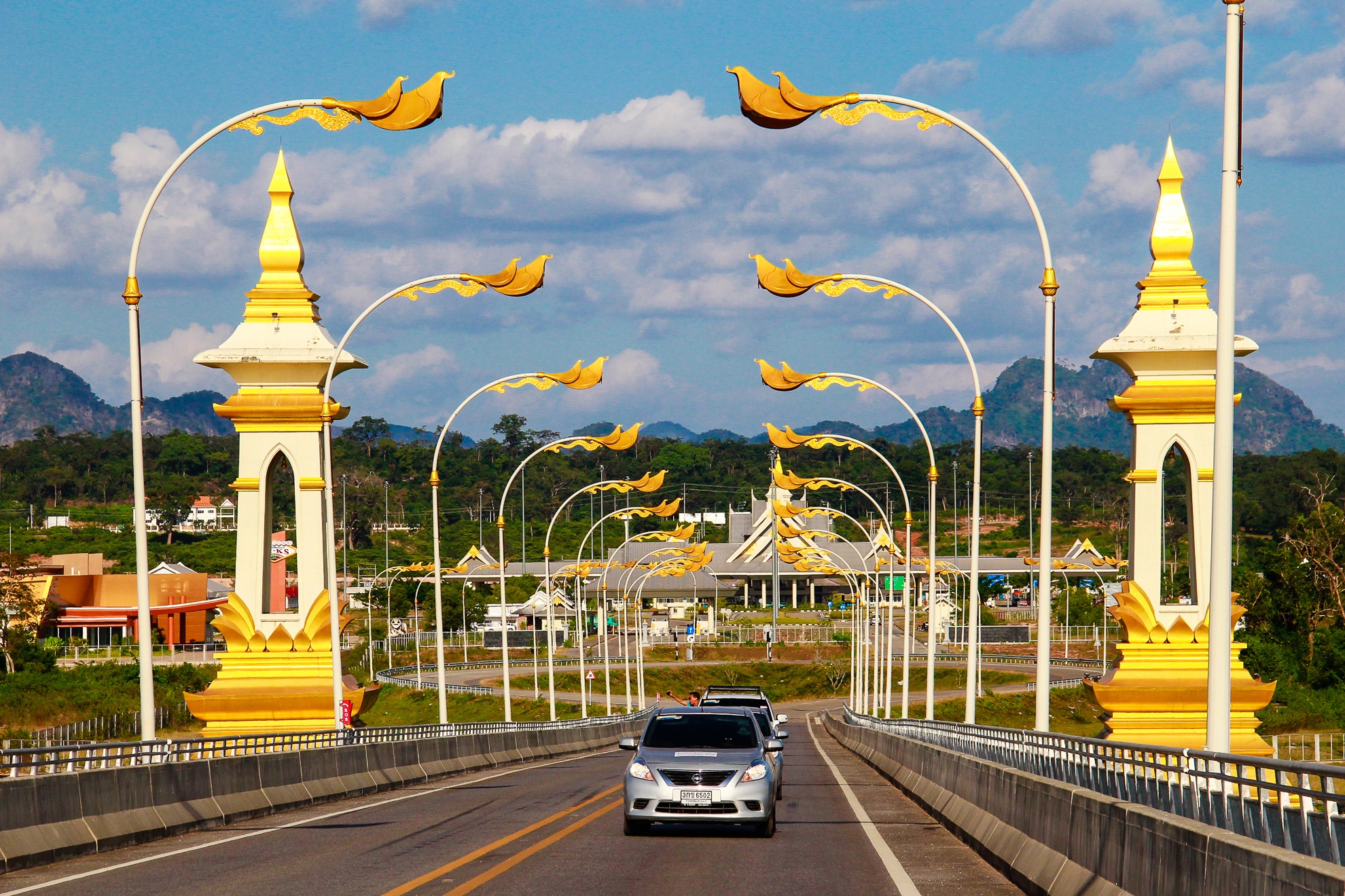 Thủ tục xuất cảnh Lào và nhập cảnh Thái Lan khá đơn giản chỉ mất chừng 15 phút. Để vào đất nước Thái Lan sẽ phải băng qua cây cầu Hữu Nghị Thái – Lào II: Được xem là kỳ quan kiến trúc trên biên giới hai quốc gia. Cầu xây năm 2004, khánh thành 2006, bắc qua sông Mê Kông nối tỉnh Mukdahan (Thái Lan) với Savannakhet (Lào). Dài 1600 m và rộng 12 m với 2 làn xe, đây là cây cầu thứ ba bắc qua hạ lưu sông Mê Kông, thứ hai qua biên giới Thái Lào trên sông Mê Kông.  Rồi từ đây sẽ đi tiếp về Nakhon Phanom.