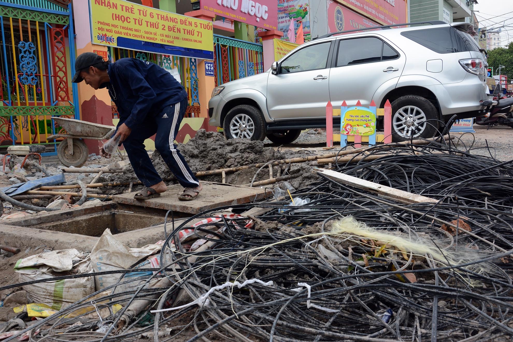 Cáp viễn thông, gạch đá nằm bừa bộn, xà bần trên lề đường, trước cửa nhà người dân.