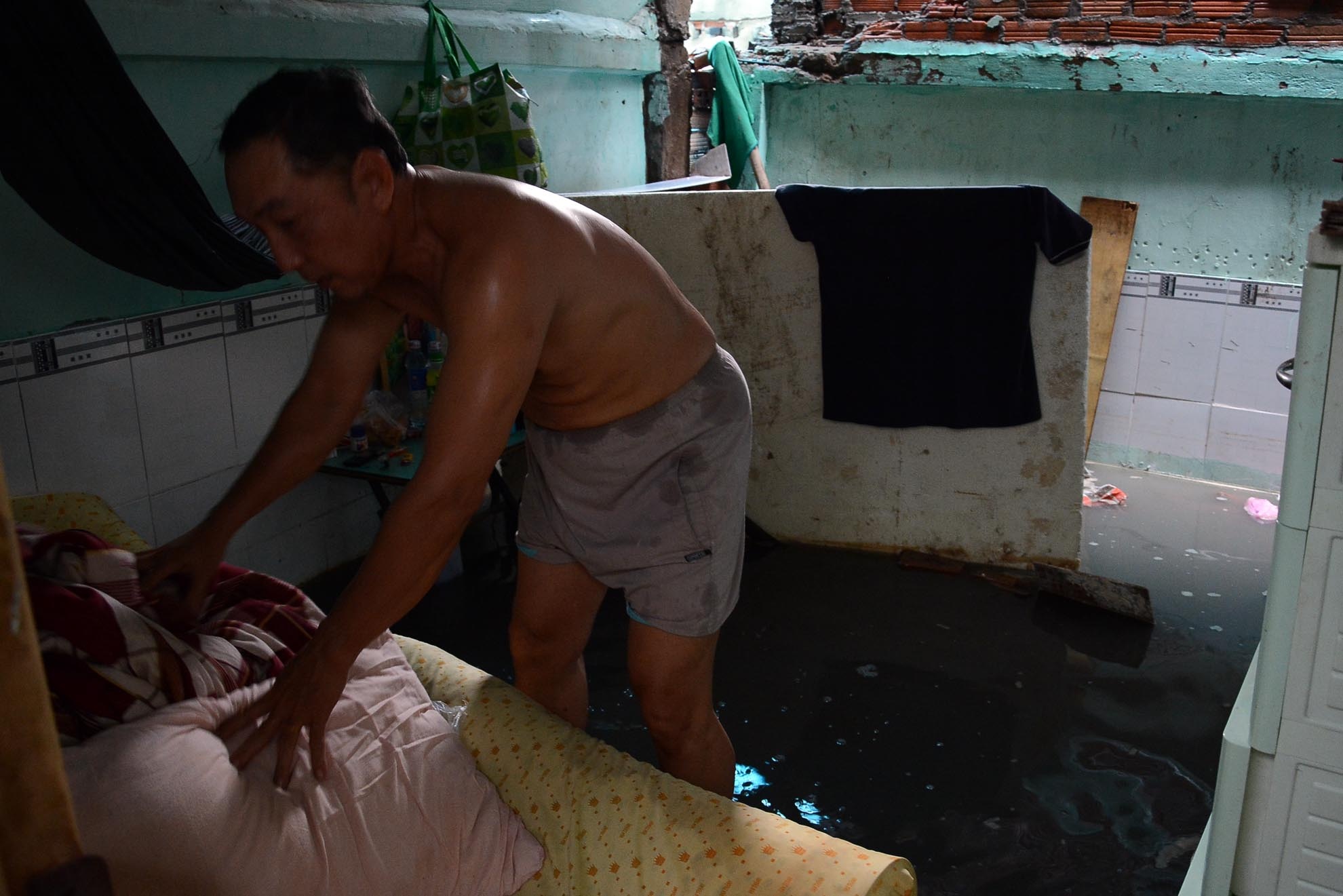 Mỗi khi trời mưa, nước từ các ống cống trào lên làm cho đường Lũy Bán Bích lại ngập lênh láng, trong ảnh: Căn nhà số 2B đường Lũy Bán Bích, phường Tân Thới Hòa, quận Tân Phú của ông Tô Hữu Nghĩa bị ngập gần nửa mét.