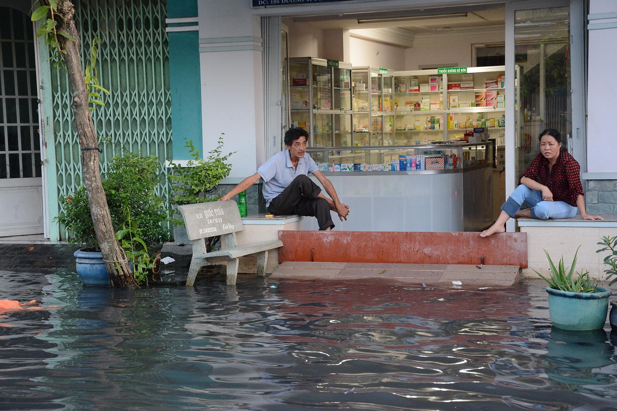 Nước tràn vào nhà dân khiến nhiều hộ hai bên đường phải dùng ván, bao tải để chắn sóng, ngăn nước tràn vào nhà.