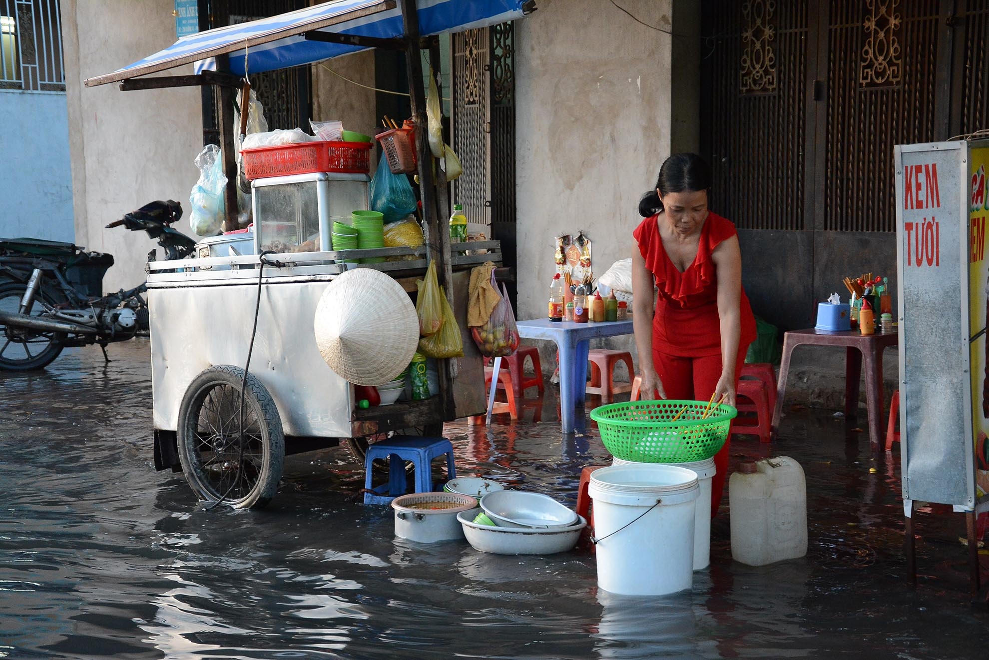 Những người buôn bán lề đường bị ế ẩm do triều cường gây ngập nước.