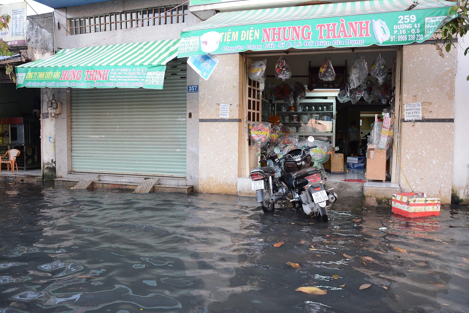 Các con đường nội bộ trong khu dân cư ở quận 6 nước ngập đen ngòm, cao nửa bánh xe, ngập hết lên cả lề đường. Người dân đi lại hết sức khó khăn.