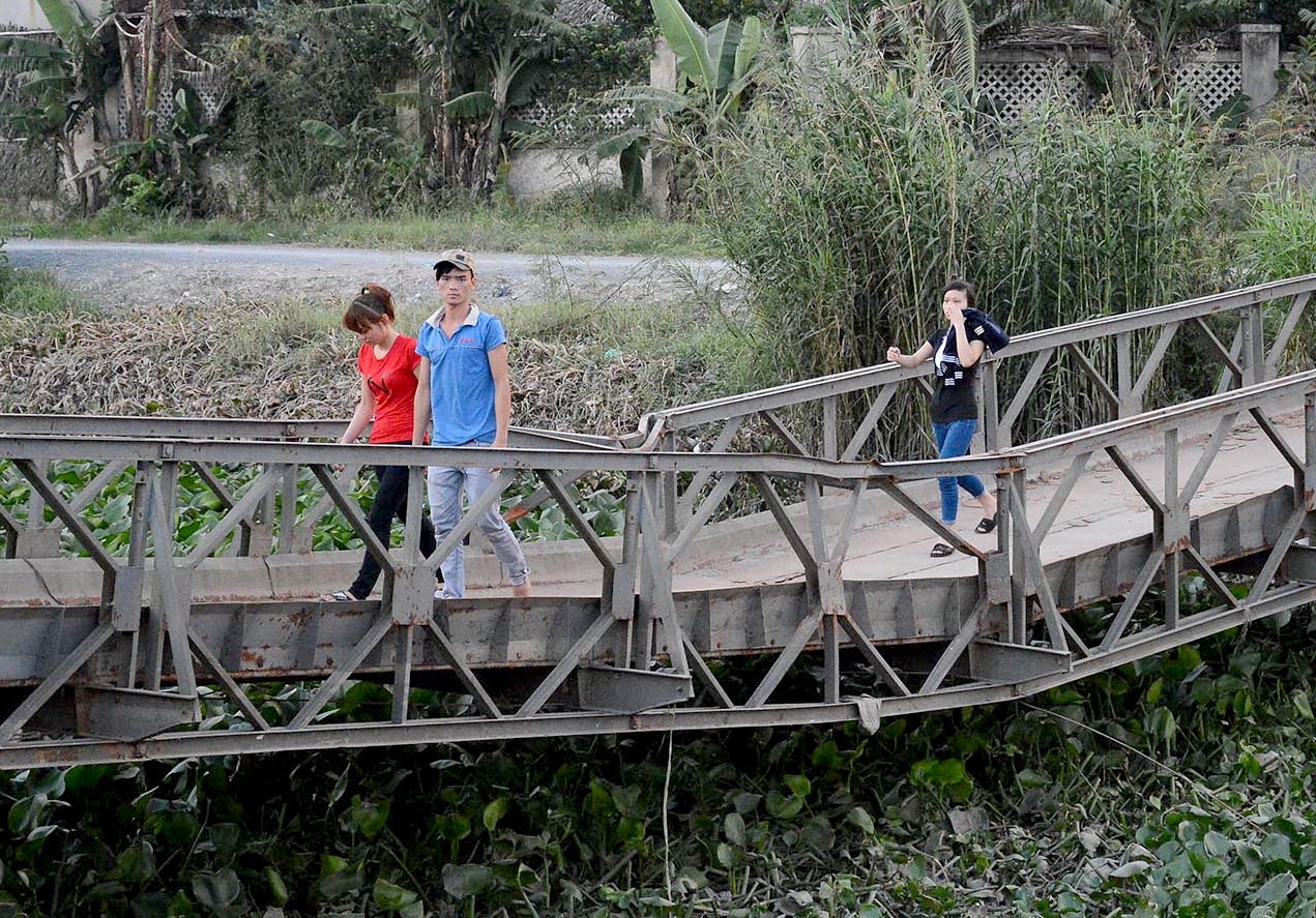 Người dân địa phương đã làm rào chắn đóng cầu, nhưng nhiều người, trong đó có trẻ em, học sinh vẫn cố tình vượt qua để đi sang bên kia, bất chấp nguy hiểm.