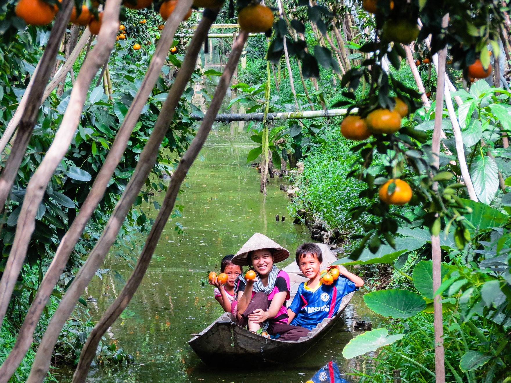 Nếu như bạn quá mỏi chân để dạo chơi khám phá khu vườn thênh thang thì có thể ngồi trên chiếc xuồng ba lá nhỏ xinh, khẽ khoát nước mà lướt đi giữa hai hàng quýt vàng óng ả. 
