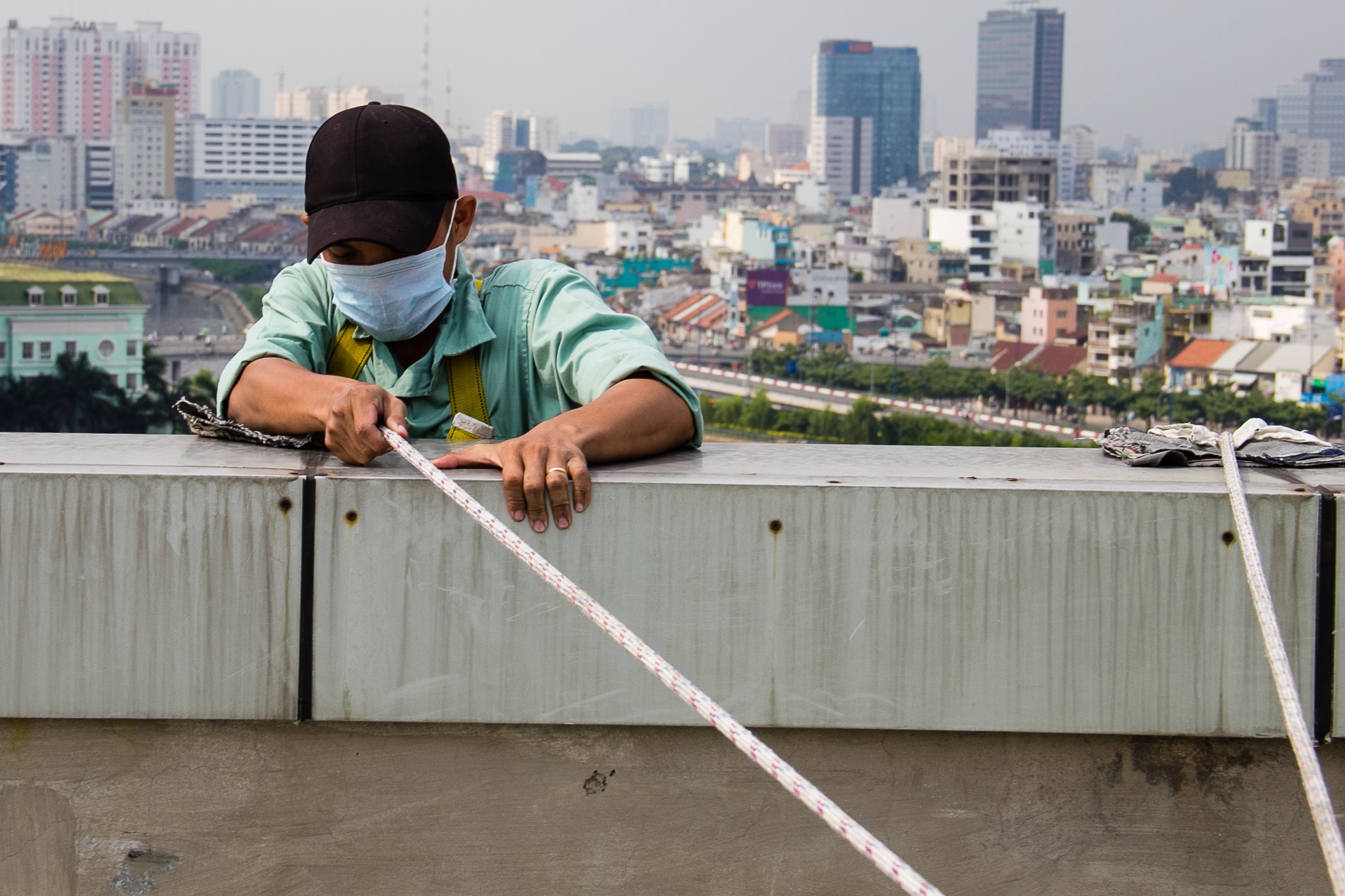 Sau khi đã móc khóa an toàn, công nhân sẽ leo xuống ngồi vào ghế đu và bắt đầu công việc. 