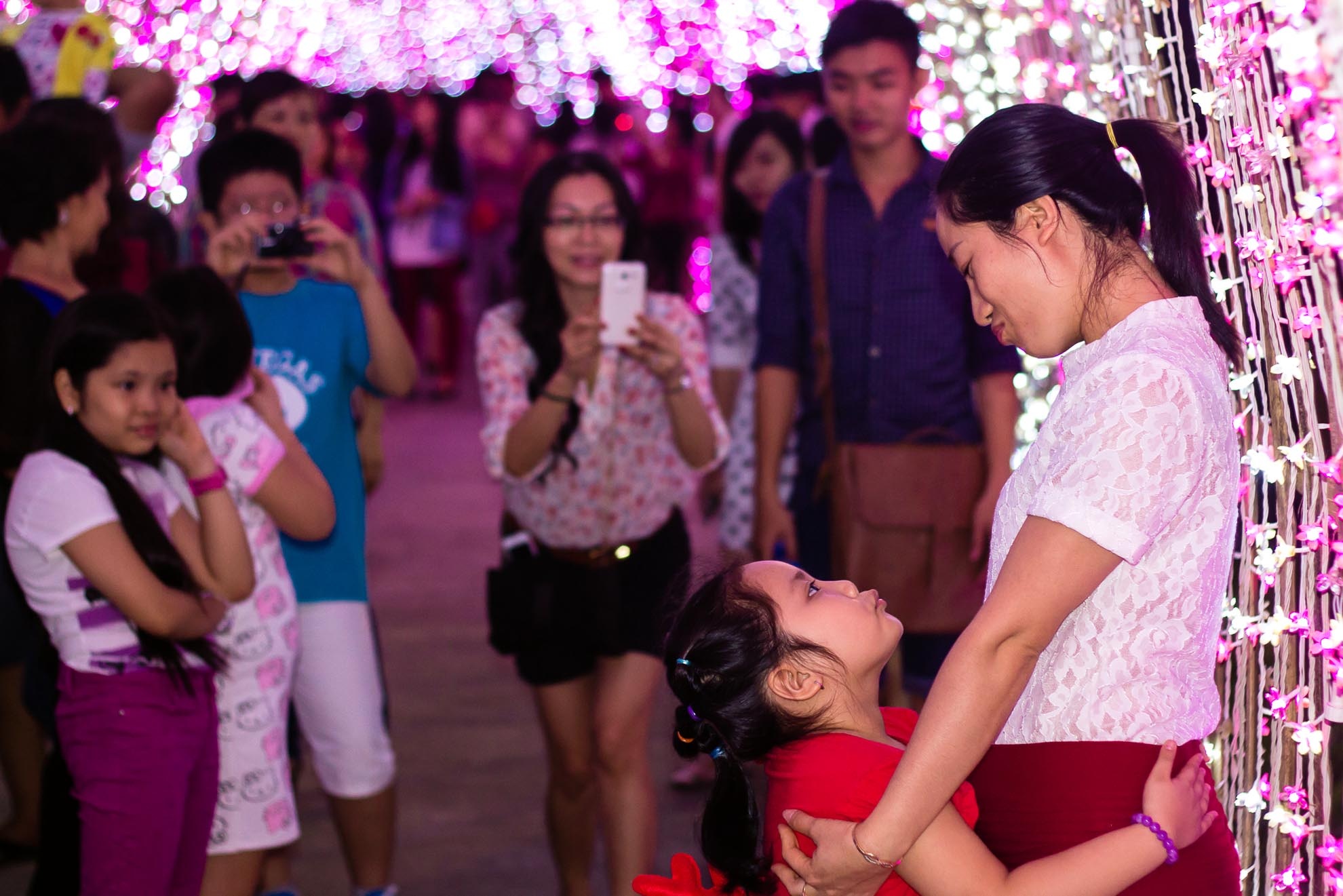 Mặt dù nhà ở xa, nhưng chị Thủy cùng con gái yêu cũng đi gần chục cây số để đến tham quan khu đèn led trong công viên Tân Phú, hai mẹ con tự tin tạo dáng trước hàng ngàn ánh đèn lấp lánh.