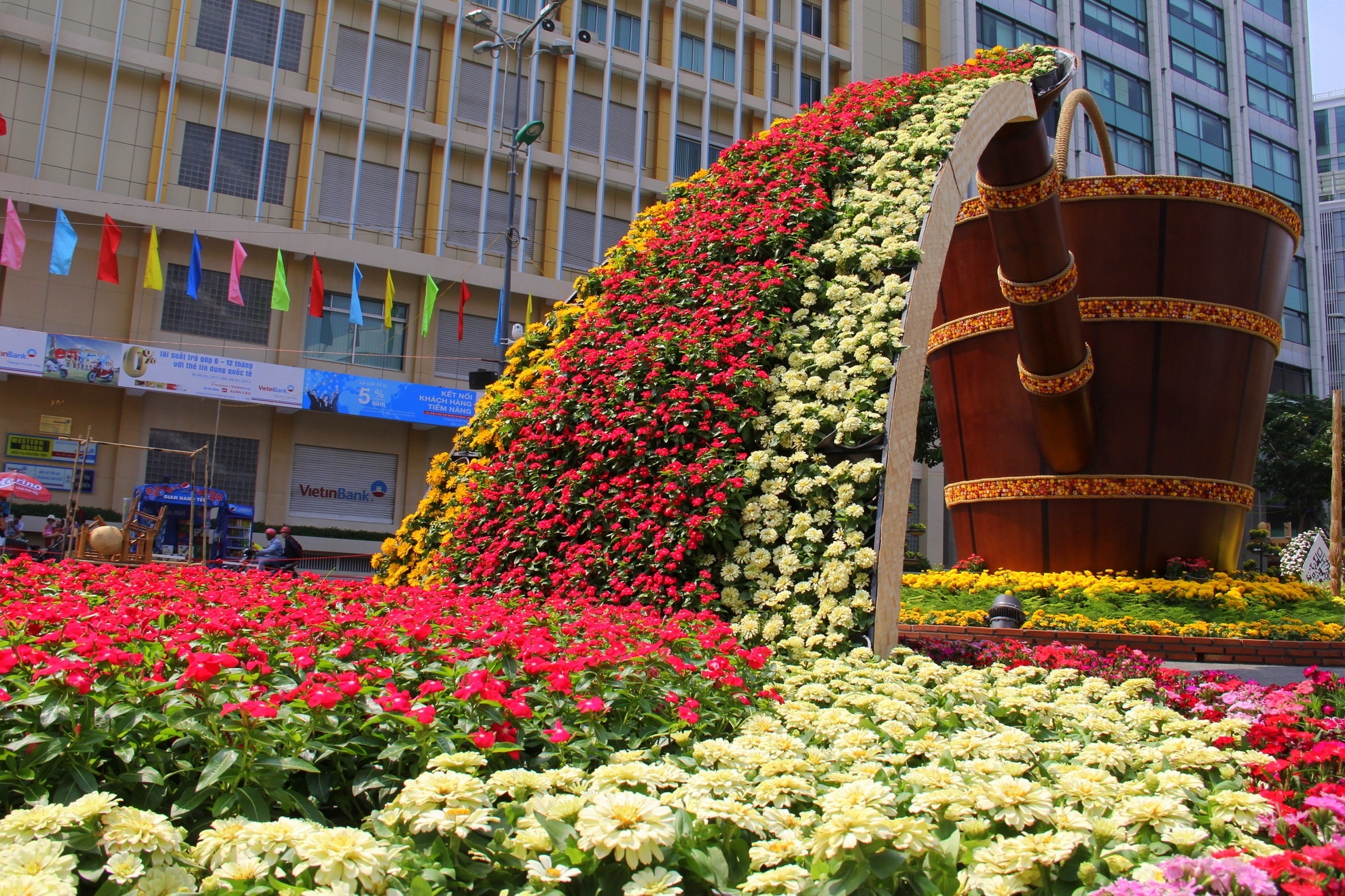 Chiếc ấm không lồ tuôn chảy muôn sắc hoa xuân là lời cầu chúc năm mới vạn sự như ý.