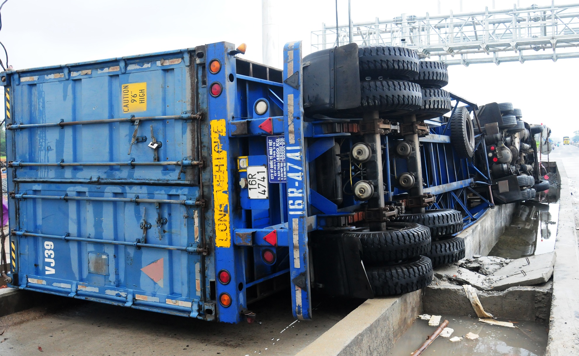 Xe container lat giua quoc lo, hang tan banh bi hong hinh anh