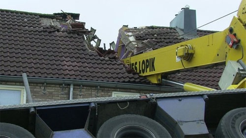 Mái nhà hàng xóm bị hư hại nặng nề khi va đập với cần cẩu.