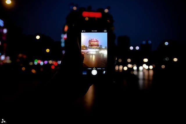 Chiếc điện thoại là trung tâm của tấm hình, còn hình ảnh có được từ camera điện thoại sẽ thể hiện chủ thể chính, cho người xem biết được tác giả đang đứng tại địa điểm nào.