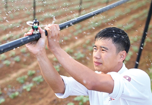 Bùi Quốc Việt thiết lập hệ thống tưới phun sương cho khoai tây Đà Lạt trong nhà kính - Ảnh: Mai Vinh.