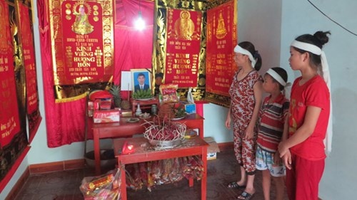 Mẹ con chị Loan đau buồn bên bàn thờ chồng, cha. Ảnh: Việt Hương.