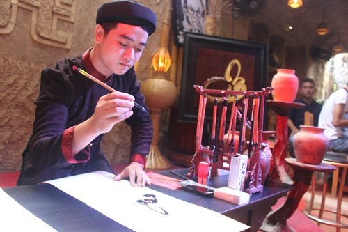 Ong do 9X dep trai tang thu phap cho ban tre xu Hue hinh anh