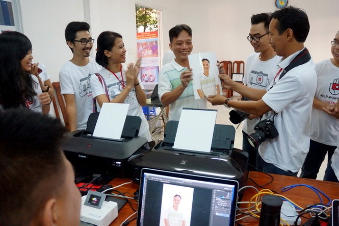 Anh Nguyễn Văn Hùng, bộ đội phục viên ở P.10, Q.10, TP.HCM (đứng giữa) là người đầu tiên được chụp ảnh miễn phí và vui mừng nhận ảnh tại điểm số 5 Đinh Tiên Hoàng.