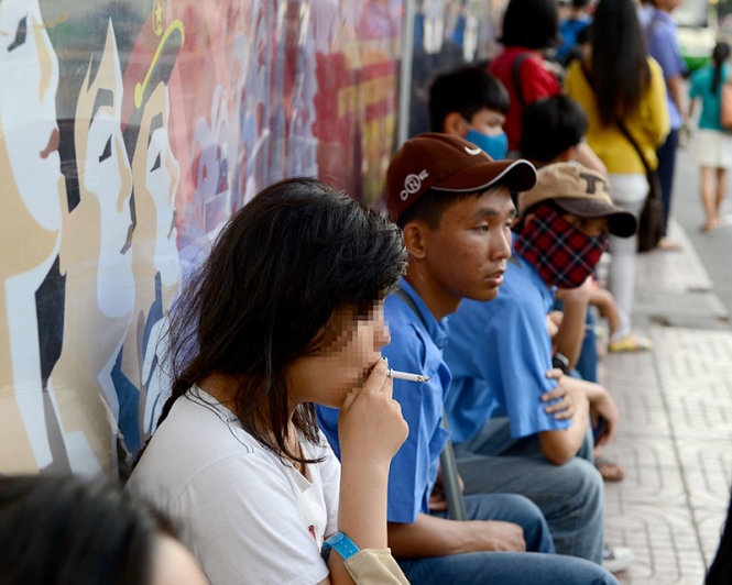 Một bạn nữ hút thuốc tại trạm chờ xe buýt