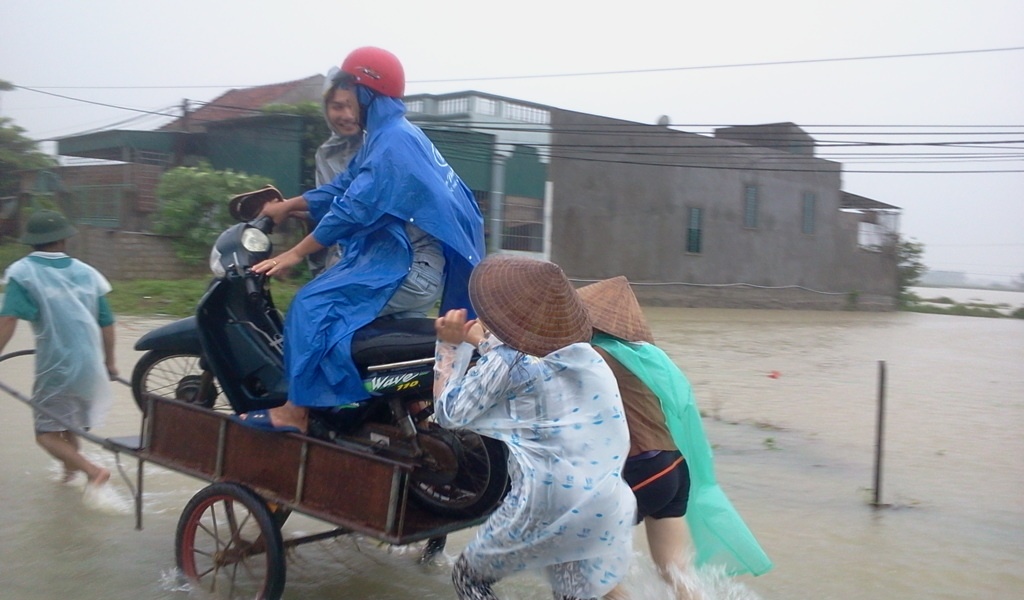 Dich vu cho xe may va nguoi an theo mua lu hinh anh