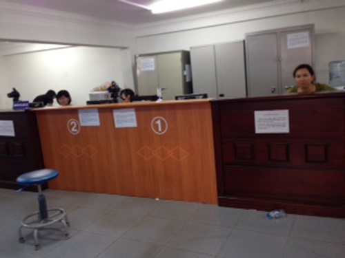 Trong khi bên ngoài nhiều người phải chờ nộp hồ sơ đổi giấy phép lái xe (ảnh trên) thì bên trong nơi giải quyết hồ sơ vẫn vắng hoe