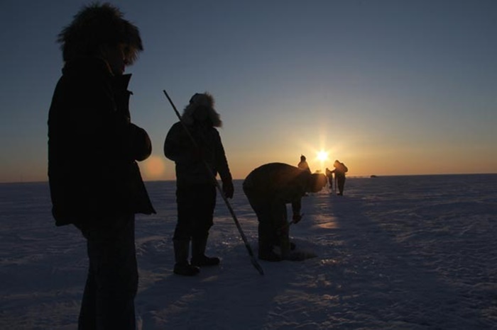 Ngư dân làm việc bên cạnh các hố băng đào trên mặt hồ.