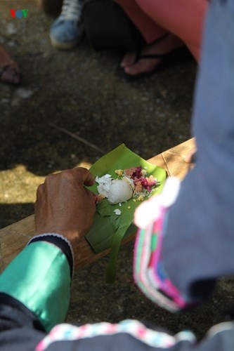 Khấn xong, trưởng lễ lấy thức ăn trên mâm cúng đặt lên tấm ván đu, mỗi loại một ít.