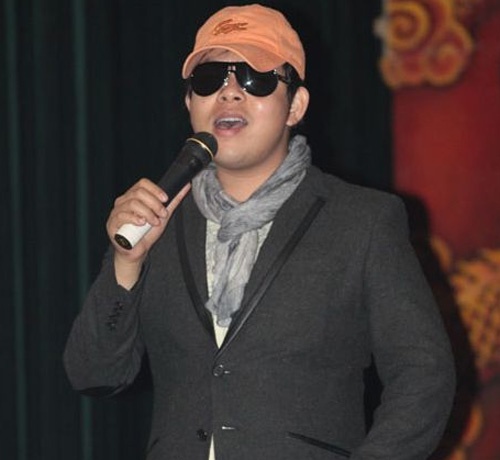 Nam ca sỹ Quang Lê đeo kinh râm trong trời tối.