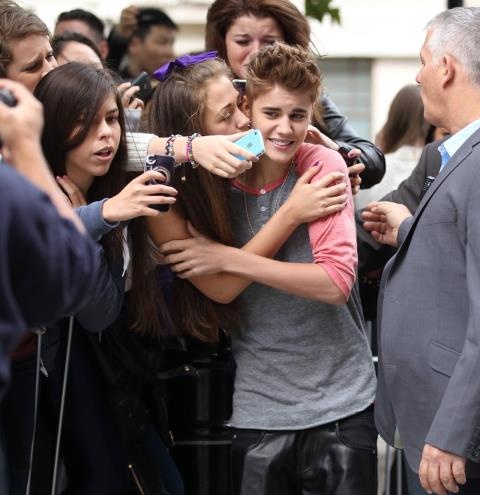 Người hâm mộ nữ ùa đến hôn Justin Bieber bên ngoài khách sạn ở London (Anh) hồi năm 2012.
