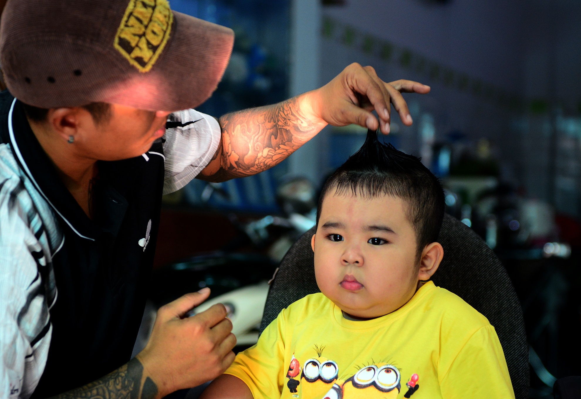 Sau giấc ngủ trưa, cậu nhóc 4 tuổi rưỡi dường như vẫn chưa thể tỉnh táo. Với Ku Tin, việc được vuốt keo, chải tóc hơn là công việc quen thuộc. Do đó, cậu nhóc rất ngoan ngoãn ngồi yên để được  “đẹp trai” hơn.