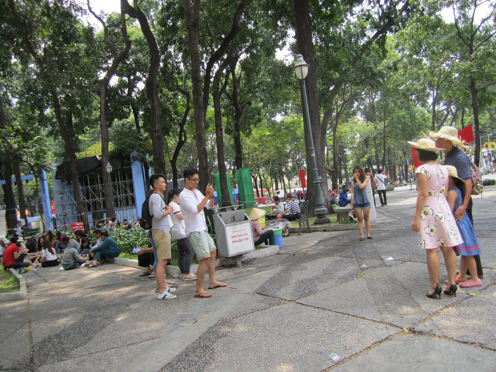 Một gia đình đi thăm thú TP HCM, nhờ người khác chụp ảnh lưu niệm.