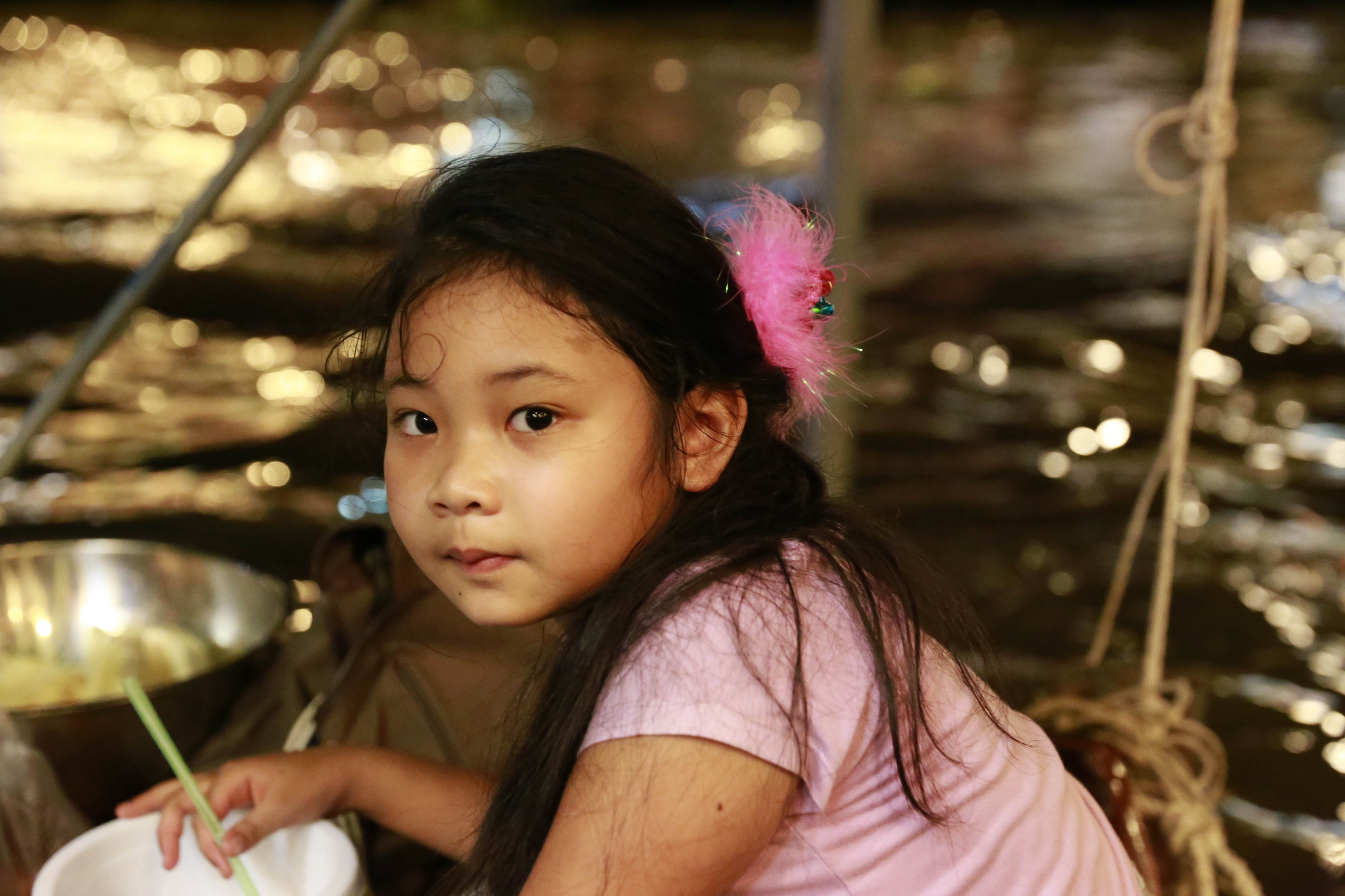 Bé gái theo phụ mẹ bán hàng trên thuyền.