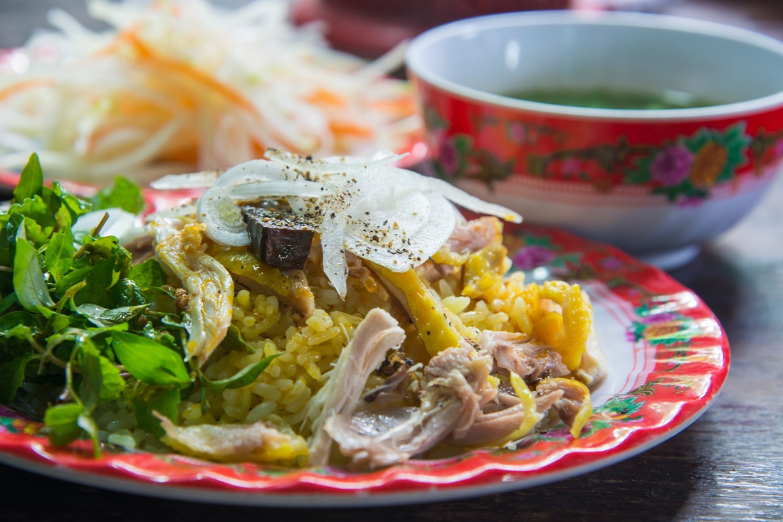  Cơm gà phố cổ là sự kết hợp tròn vị của những hạt cơm vừa chín tới, nước luộc gà béo ngậy và phần thịt gà trộn với ít hành tây. Rau ăn kèm món này là rau răm với thuộc tính nóng để khắc chế. Hai trong số những quán cơm nổi tiếng nhất của phố cổ là cơm gà Bà Buôi, cơm gà Bà Ty. www.hungontheworld.com