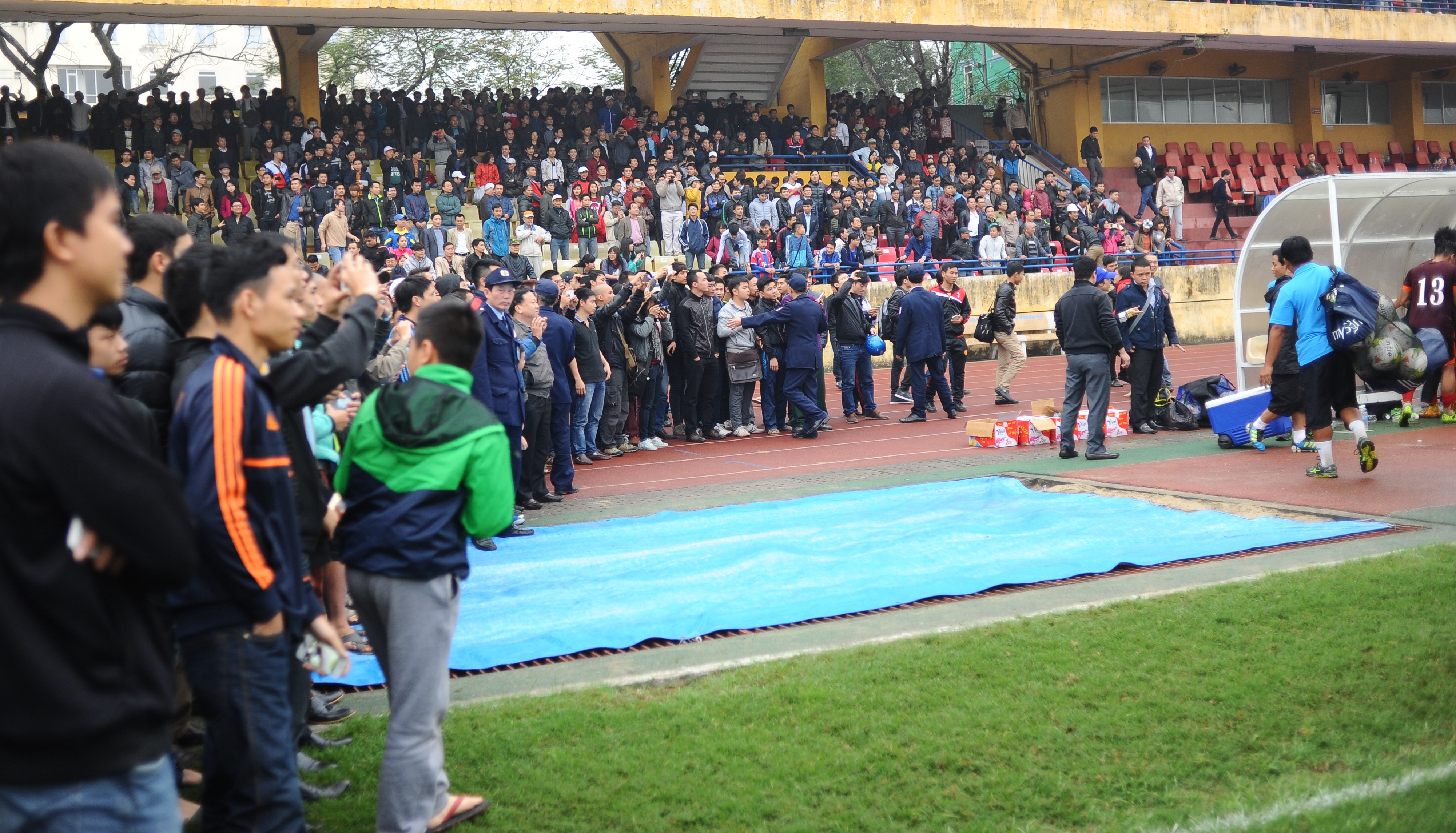 CĐV tràn xuống sân bao quanh khu vực kỹ thuật của ĐT Olympic Việt Nam. 