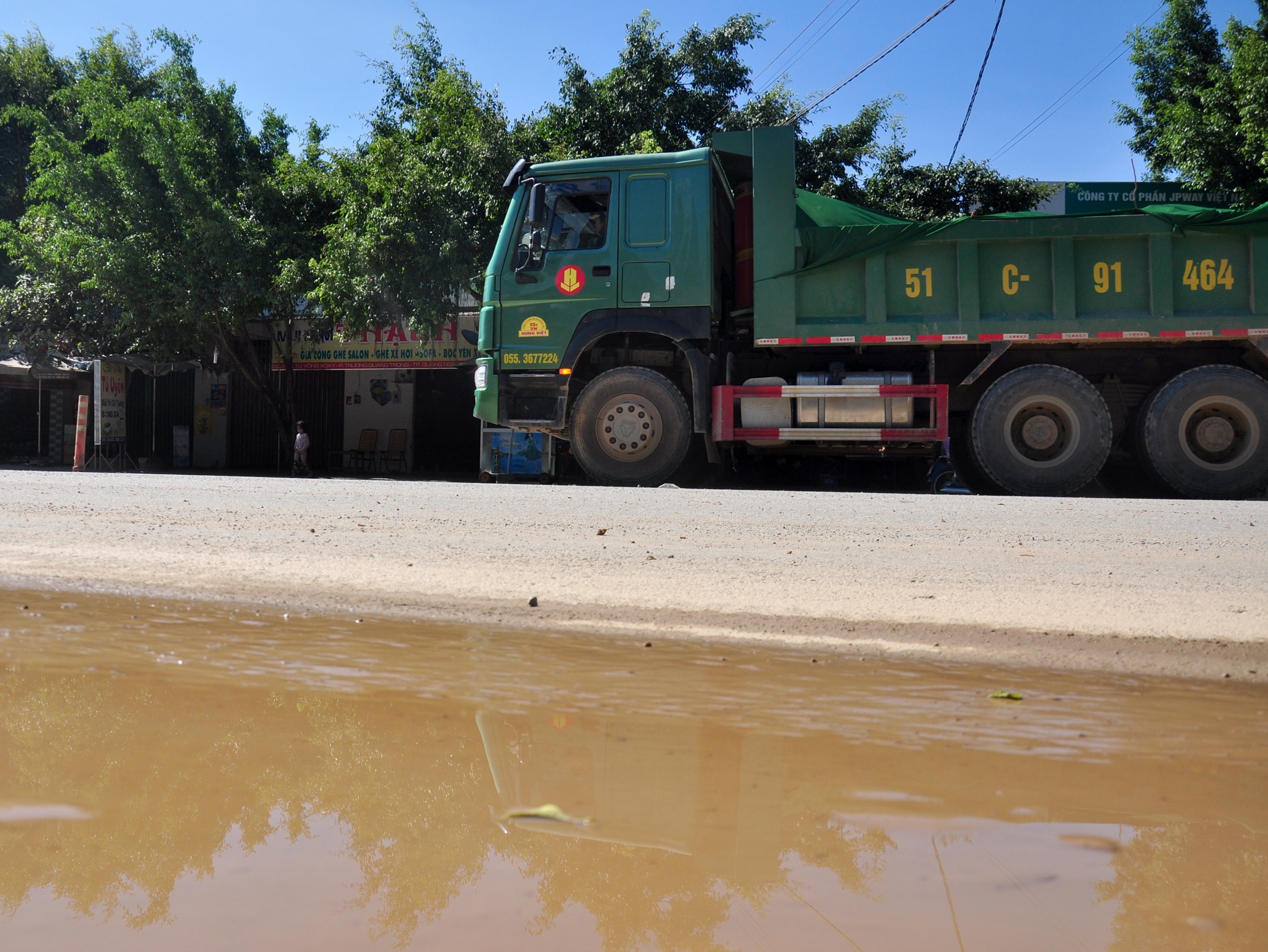 Xe cong trinh de roi vai vat lieu, nuoc chay tran tren quoc lo 1 hinh anh