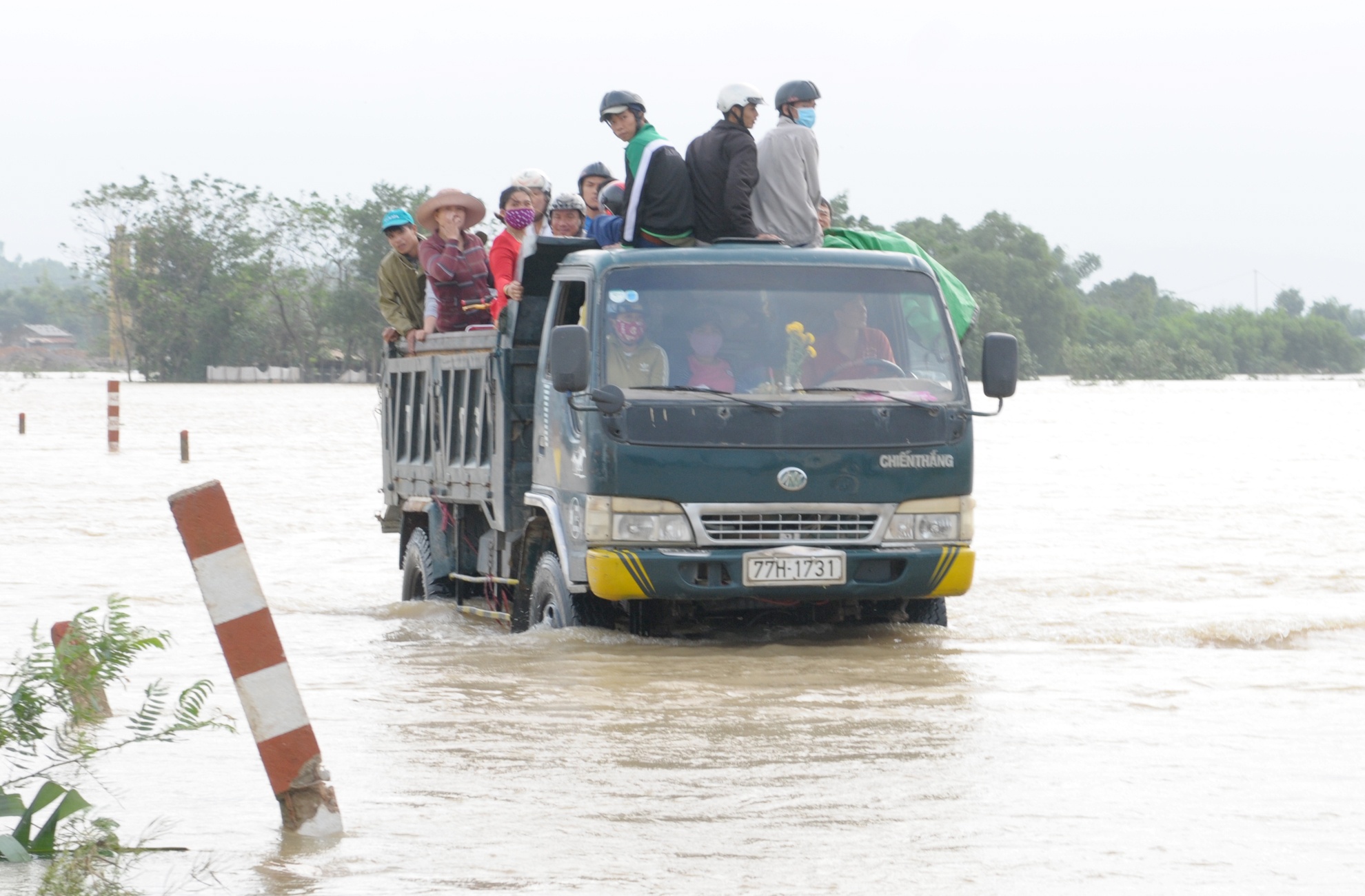 Hang chuc nguoi vat veo tren xe ben bang qua lu du hinh anh