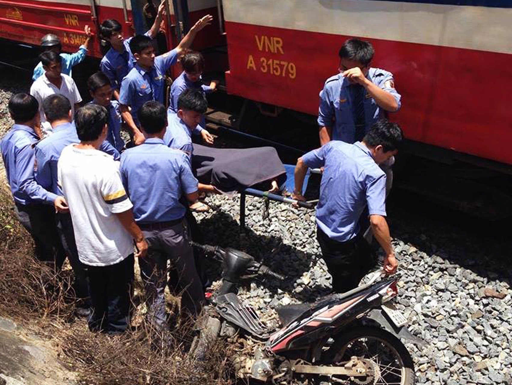 Tau hoa hat vang phu nu di xe may bang qua duong sat hinh anh