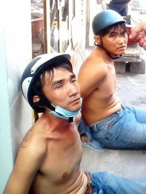 Hai tên cướp giật bị người dân quật ngã giao công an. Ảnh: Khánh Trung.