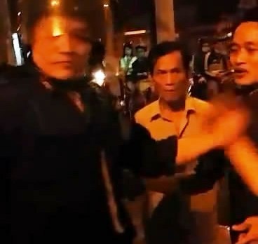 Cảnh sát cơ động túm cổ người dân. Cắt từ clip.