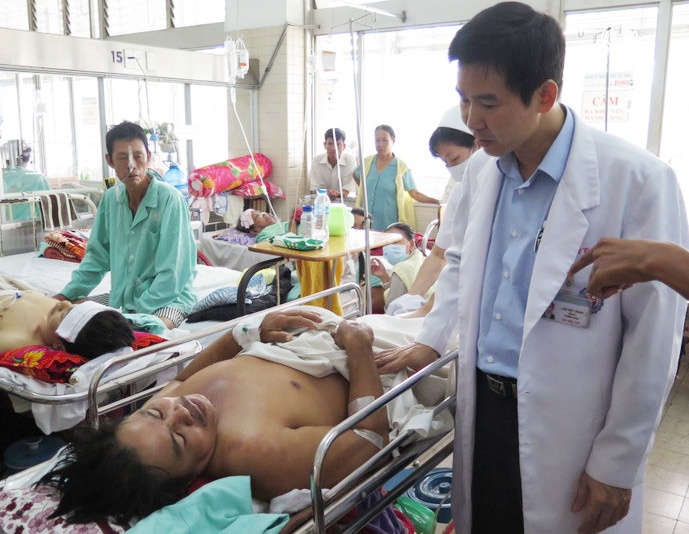 Bác sĩ Trung đang thăm khám cho bệnh nhân bị tai nạn lao động trong vụ sập giàn giáo nhà hàng tiệc cưới ở Cần Thơ. Ảnh: Khánh Trung.