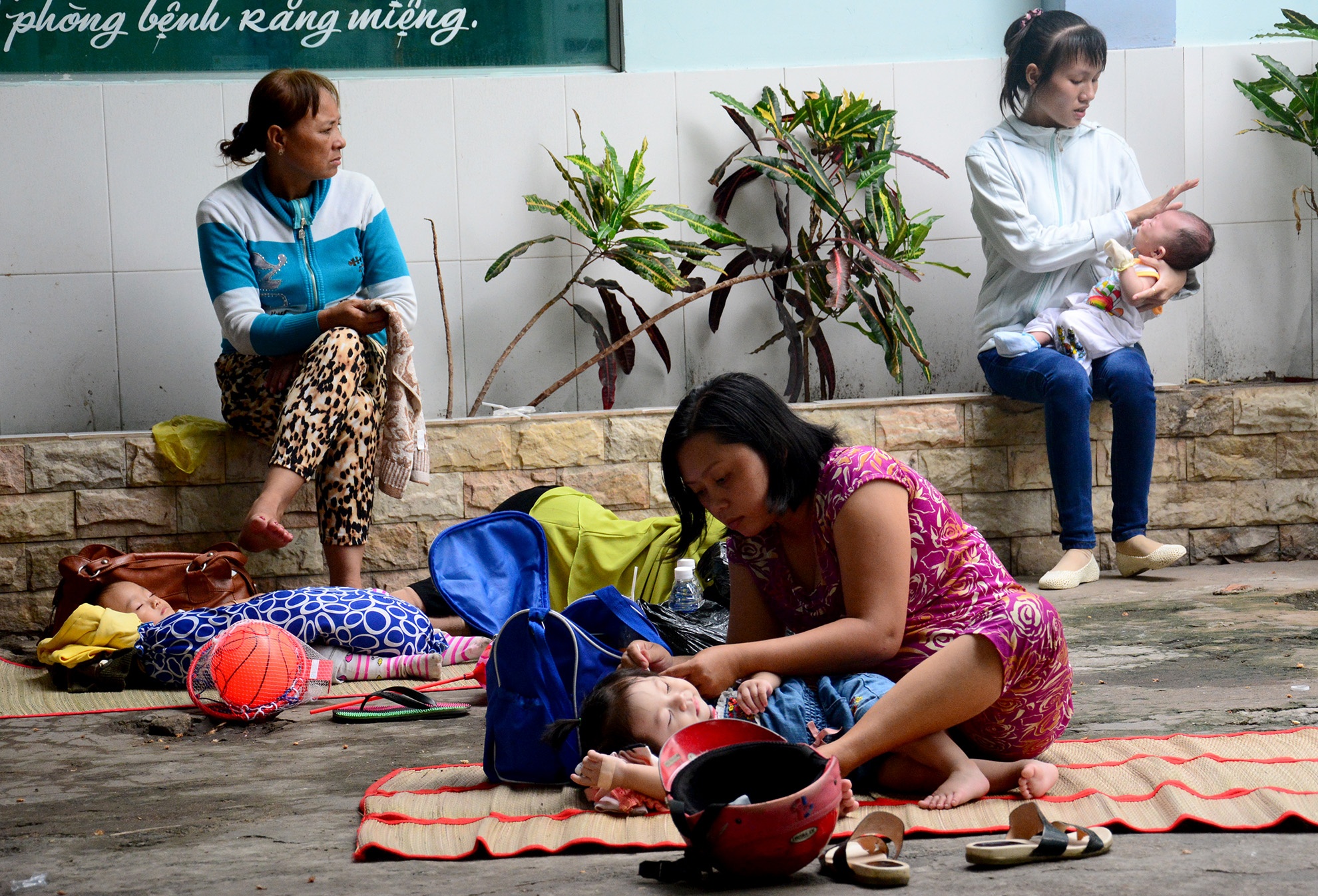 Cảnh cha mẹ bệnh nhi phơi nắng, phơi mưa ở sân bệnh viện. Ảnh: Lê Quân. 