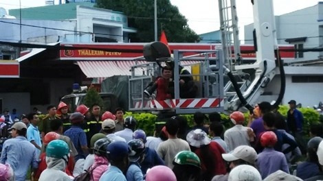 Lực lượng cảnh sát PCCC đã dùng xe thang, đưa hai chiến sĩ tiếp cận nam thanh niên và đưa người này tiếp đất an toàn.   