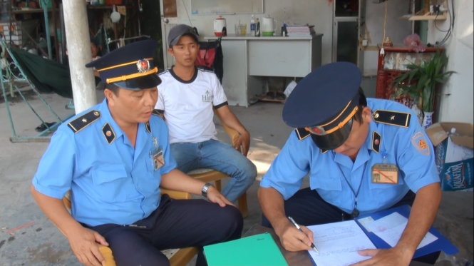 Thanh tra giao thông lập biên bản xử lý xe gắn biển số đỏ giả - Ảnh: Chế Thân